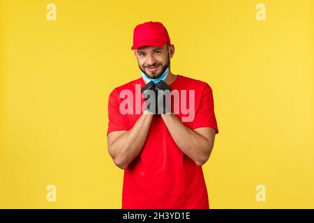 Expresslieferung während Pandemie, covid-19, sicherer Versand, Online-Shopping-Konzept. Netter bärtiger Kurier mit wunderschönem Blick, tak Stockfoto