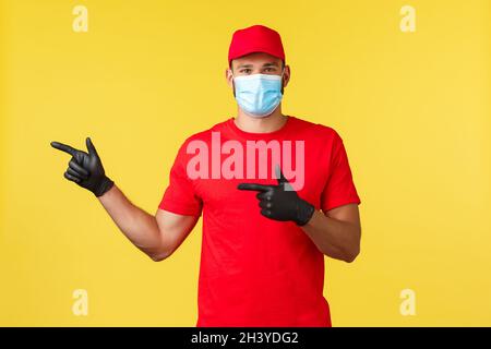 Expresslieferung während Pandemie, covid-19, sicherer Versand, Online-Shopping-Konzept. Schöner Kurier in roter Uniform, schwarzer Handschuh Stockfoto