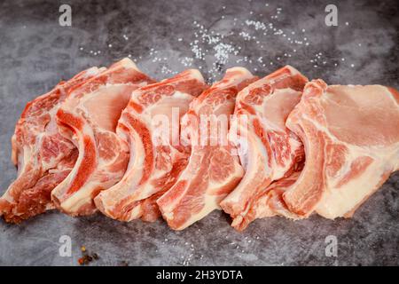 Rohes Schweinekotelett in isoliertem auf grauem Hintergrund. Stockfoto