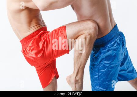 Zwei Männer Boxer kämpfen muay thai kniekniekick Boxen weißen Hintergrund. Stockfoto