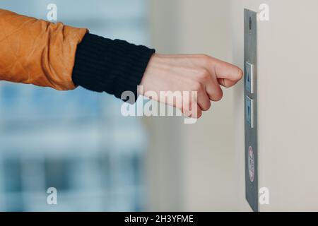 Nahaufnahme des Zeigefinger-Knöchels durch Drücken des Tastenhebels während des Coronavirus-Pandemiekonzepts covid-19-Quarantäne Stockfoto