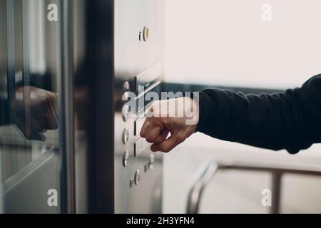 Nahaufnahme des Zeigefingers, der während des Coronavirus-Pandemiekonzepts covid-19 auf den Tastenaufzug drückt Stockfoto