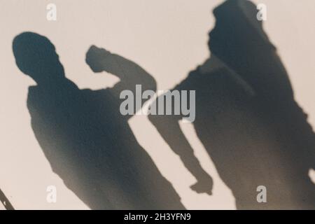 Ellenbogen Anstoßen Sicherheit Gruß von zwei Menschen Schatten an der Wand des Coronavirus COVID-19. Neuer Normalwert. Stockfoto