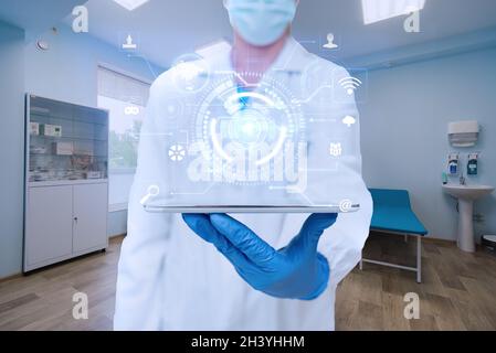 Arzt im Labor trägt Handschuhe mit Einem Tablet und zeigt futuristische Technologie. Scientist Inside Workshop Mit Tab Pres Stockfoto