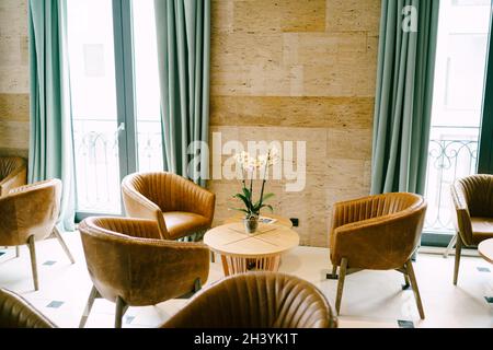 Bellagio, Italien - 07. juni 2020: Ein heller Raum mit Ausgang zum Balkon mit runden Tischen und braunen Sesseln. Stockfoto