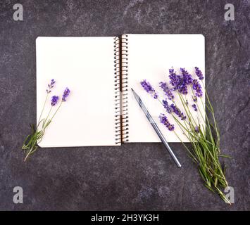 Nachbau aus offenem, leerem Notizblock und Lavendelbukett Stockfoto