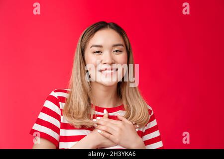 Close-up zart berührt junge charmante asiatische blonde Mädchen drücken Palmen Herz dankbar lächelnd breit schätzen schöne romantische comp Stockfoto