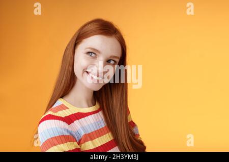 Alberne kokett gut aussehende rothaarige Mädchen machen erste Bewegung Auschecken Kerl stehend Profil Drehen links lächelnd fasziniert glanci Stockfoto
