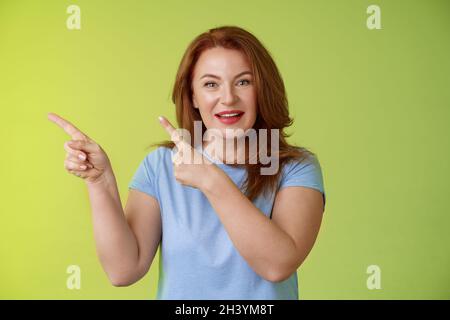 Neugierig enthusiastisch wunderschöne Rotschopf weiblich fasziniert zeigen oben links Ecke Frage stellen interessante Produkt reden Shop Stockfoto