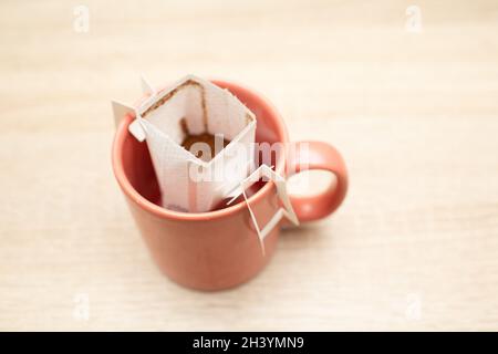 Kaffee tropft in die Tasse. Alternativer Brühkaffee in Papierfiltertüten. Stockfoto
