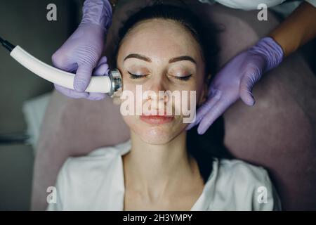 Nahaufnahme einer Kopffrau, die im Schönheitssalon eine Elektroporation mit Phonophorese erhalten hat. Stockfoto