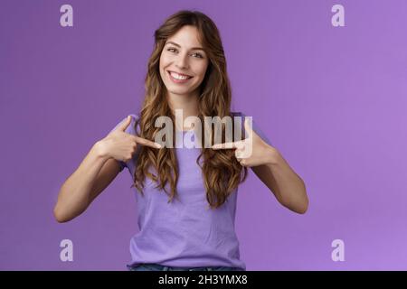 Fröhlich motivierte professionelle durchsetzungsfähige lockige Frau zeigt sich in der Mitte lächelnd schlagen breit eigene Hilfe teilnehmen wollen Stockfoto