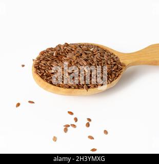 Braune trockene Leinsamen in einem Holzlöffel auf weißem Hintergrund Stockfoto