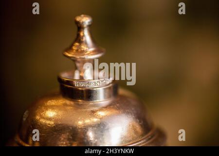 Eheringe Detail auf Metall-Kelch mit Brautstrauß im Hintergrund, Braut und Bräutigam Hochzeit Set, einfache Details Stockfoto