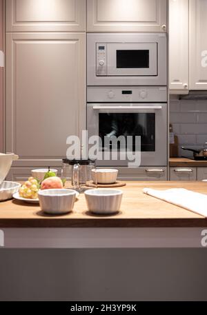 Ein Teil der Küche mit Geschirr und Obst auf dem Tisch. Stockfoto
