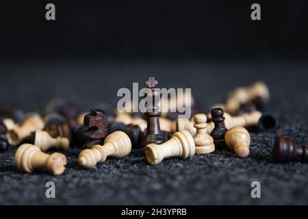 Verstreute Schachfiguren auf einem verschwommenen schwarzen Hintergrund. Stockfoto