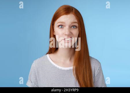 Verwirrt betäubt junge zweifelhaft Rotschopf Mädchen sehen voll Unglauben grinsen unsicher runzelig runzelnd zögerlich stehend enttäuscht Stockfoto