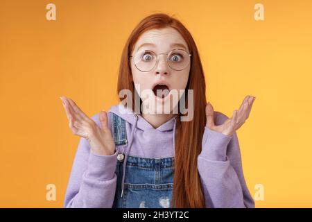 Nahaufnahme schockiert sensibel besorgt junge Panik Rotschopf Frau Sorgen Tropfen Kiefer keuchend heben Hände verbreiten freak out sur Stockfoto