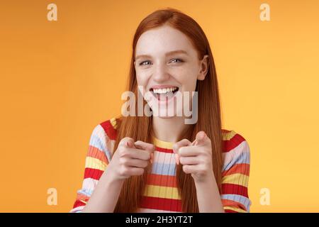 Enthusiastisch sorglos freundlich rothaarige Mädchen zeigt Finger-Pistolen Kamera lächelnd freudig gratuliert Freund genial Wahl Stockfoto