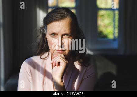 Porträt einer nachdenklichen älteren kaukasischen Frau im Schlafzimmer, die vor die Kamera schaut Stockfoto