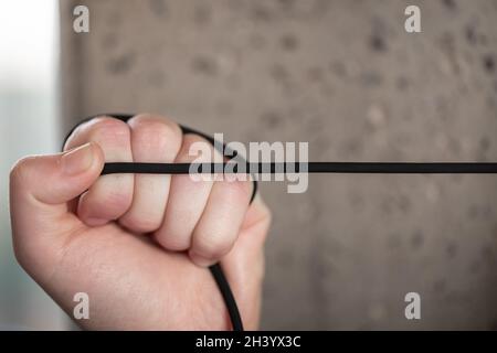 Strapazierfähige, reißfeste gummierte Kordel in den Händen von Frauen. Stockfoto