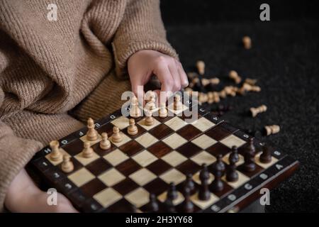 Frau, die Schachfiguren auf ein Schachbrett legt. Stockfoto