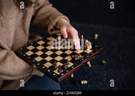 Schachbrett mit hölzernen Schachfiguren in weiblichen Händen. Stockfoto