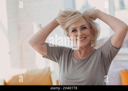 Ältere kaukasische alte Frau Porträt grauhaarige Berührung hält Haare. Stockfoto