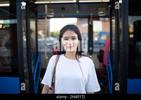 Asiatische Frau durch Türen nach der Fahrt in öffentlichen Verkehrsmitteln Bus oder Straßenbahn. Stockfoto