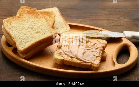 Erdnussbutter auf einer quadratischen Scheibe Weizenmehl, Frühstück Stockfoto