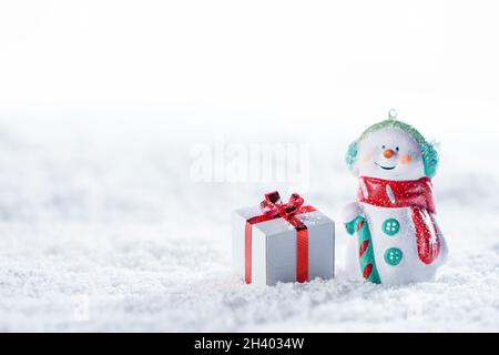 Weihnachten und Neujahr Schneemann und Geschenk auf einem weißen Schnee Hintergrund Stockfoto