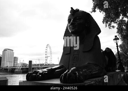 Ein Blick auf die ikonische Cleopatras-Nadel, einen Steinobelisken und eine Sphynx-ähnliche Statue am Ufer der Themse in der Stadt London Stockfoto