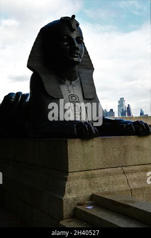 Ein Blick auf die ikonische Cleopatras-Nadel, einen Steinobelisken und eine Sphynx-ähnliche Statue am Ufer der Themse in der Stadt London Stockfoto