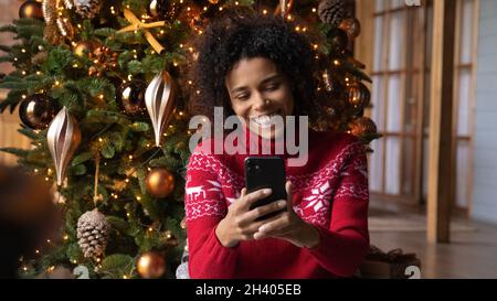 Lächelnde Birazialfrau hat einen angenehmen Videoanruf auf der Zelle Stockfoto
