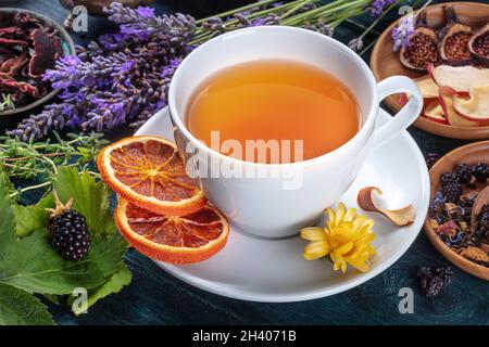 Bio-Tee. Kräuter, Blumen und Früchte um eine Tasse Tee Stockfoto