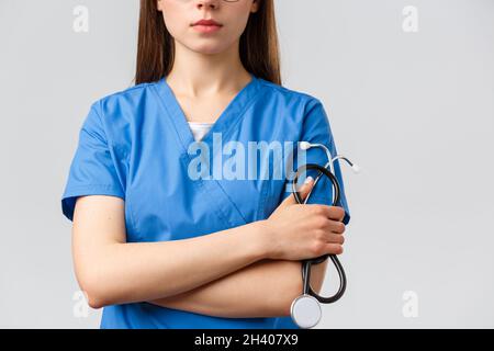 Gesundheitshelfer, Medizin, Versicherung und covid-19 Pandemiekonzept. Abgeschnittene Aufnahme einer jungen Ärztin oder Krankenschwester in blauem Scru Stockfoto