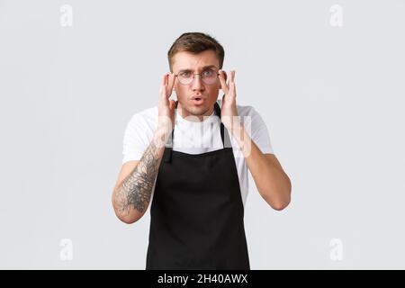 Konzept für Inhaber kleiner Einzelhandelsunternehmen, Mitarbeiter von Cafés und Restaurants. Der Kellner war fasziniert und unsicher, der Barista kam näher Stockfoto