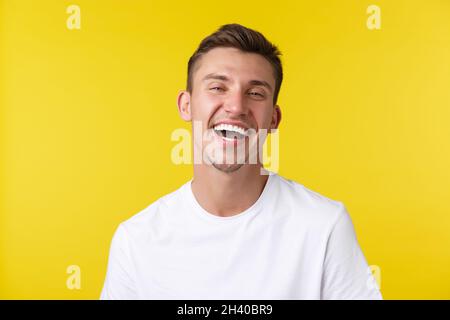 Lifestyle, Sommer und Menschen Emotionen Konzept. Nahaufnahme Porträt von gutaussehenden glücklichen Mann in einfachen T-Shirt, lachen laut und s Stockfoto