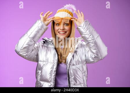 Erstaunt attraktiv fasziniert junge weibliche Reisende nehmen Sonnenbrille Check-out atemberaubende perfekte Aussicht verschneite Berge lächelnd l Stockfoto