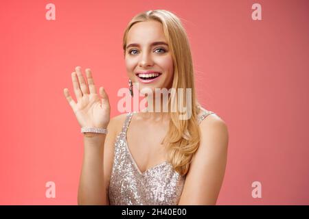 Taille-up-Studio Schuss freundlich attraktiv elegant zart blonde Frau sagen hallo winken erhobenen Hand Begrüßung Freund lächelnd Stockfoto