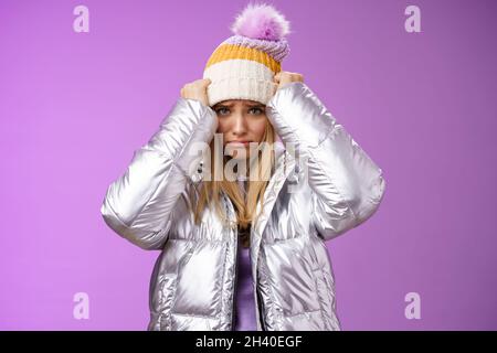 Verärgert düster beleidigt niedlich blonde Mädchen beschwert beleidigendes Verhalten Ziehen Hut Stirn runzelte schmollend traurig stehend miserab Stockfoto