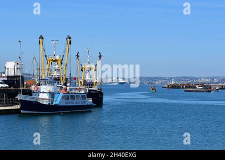 Eine Szene von größeren Seeschleppern, die am Hafen in Brixham festgebunden sind. Aufgrund einer Pandemie wurde in Torbay ein redundanter Kreuzfahrtdampfer vertäut. Stockfoto