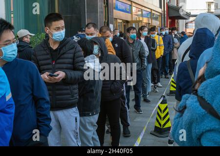 Die Bewohner stellen sich auf, um an einer Impfstelle in Peking, China, Auffrischungsimpfungen gegen COVID-19 zu erhalten. 31-Okt-2021 Stockfoto