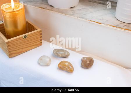 Zen-Atmosphäre weißer Hintergrund. Kerzenlicht Steine und Brust im Hintergrund Stockfoto