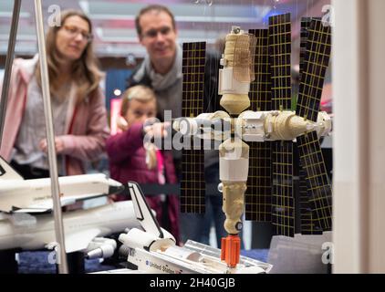 Oberthal, Deutschland. Oktober 2021. Elena und ihre Eltern schauen sich auf der Startparty in der Heimatgemeinde von Astronaut Matthias Maurer ein älteres Modell einer Raumstation an. Die 4000 Einwohner zählende Gemeinschaft hat seit Wochen Weltraumfieber. Heute feiern die Saarländer den Start von Astronaut Matthias Maurer ins All, der nun für Mittwoch, 03.11.2021, geplant ist. Quelle: Harald Tittel/dpa/Alamy Live News Stockfoto