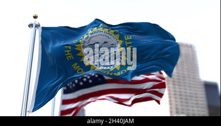 Die Flagge des US-Bundesstaates South Dakota winkt im Wind mit der Flagge der amerikanischen Sterne und Streifen im Hintergrund. Stockfoto