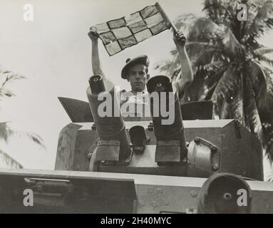 Ein Vintage-Foto um 1942, das einen Soldaten des Bataillons von Argyll & Sutherland Highlanders British Army aus dem Jahr 2nd in einem gepanzerten Lanchester 6x4-Revolver mit einer Flagge zeigt. Während der japanischen Invasion von Malaya und dem Fall von Singapur Stockfoto