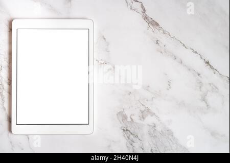 Digitaler Tablet-Computer mit vertikalem weißen leeren digitalen Bildschirm für Mockup oder Platz für Text auf einem grauen Marmorhintergrund. Draufsicht, flach liegend Stockfoto