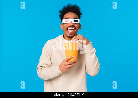 Unterhaltung, Lifestyle und People-Konzept. Sorgloser, glücklicher und entspannter afroamerikanischer Mann in weißem Pullover, der lustig in zusieht Stockfoto