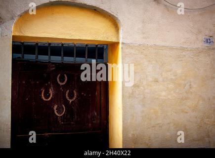 Vier umgedrehte Hufeisen an einer großen Eingangstür in Italien, die gerade die Nummer dreizehn war. Glück oder Pech. Stockfoto